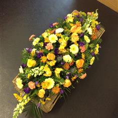 Casket spray in golds, creams and purples