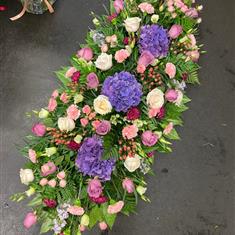 Casket spray in pinks and purples