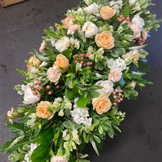 Casket spray in peach and cream