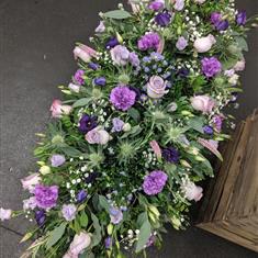Casket spray in purples and lilac