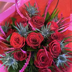 12 red roses and thistle in vase